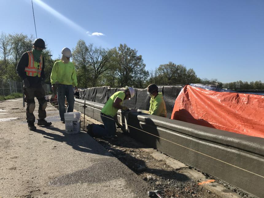 Crews pour concrete wall around Highland Park Reservoir.