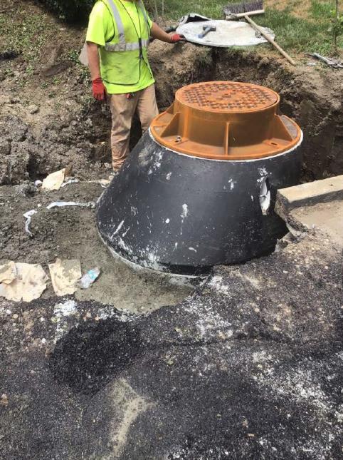 Crews expose manhole on Keefe Street for sewer repairs.