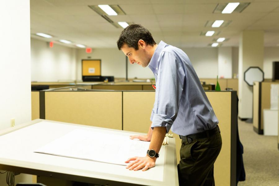 Rob Herring, Project Manager and reviewer on our Development Services team looks over tap-in plans at our 1200 Penn Avenue office.