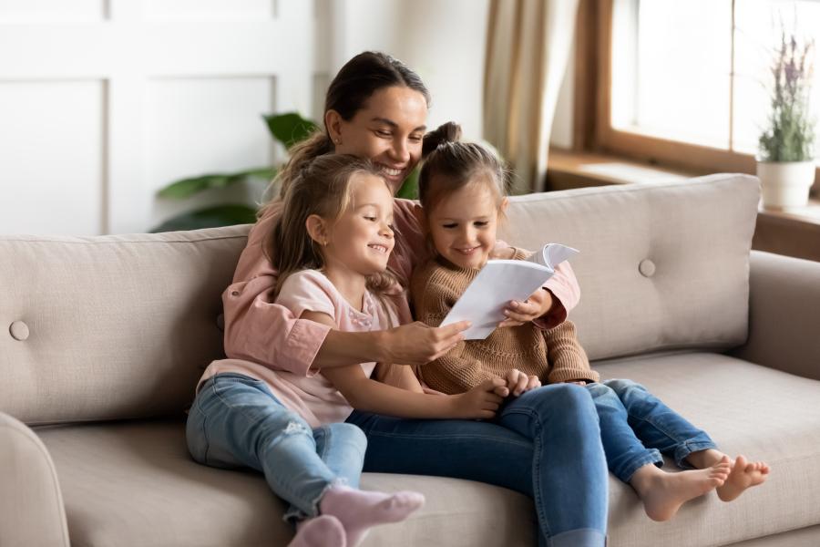 Young mother reading a story to her two young daughters