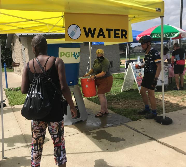 Attendees fill water containers at a Bike PGH summer event