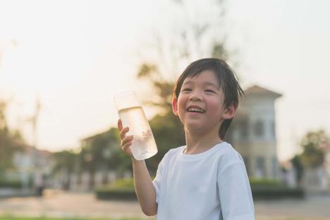 A boy holding a glass of water