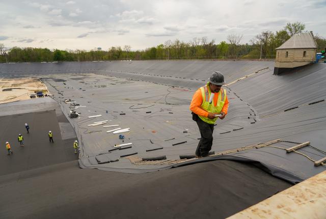 Construction worker adding new liner to the Highland II Reservoir.